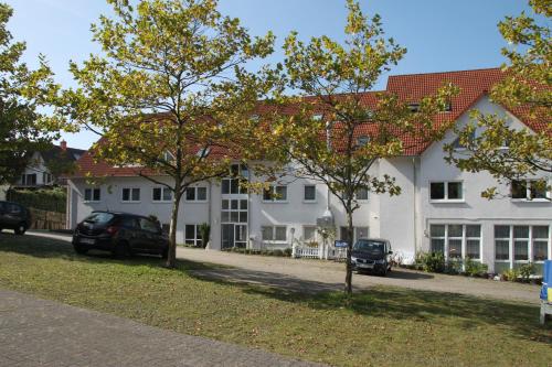 a large white house with cars parked in front of it at Hotel Leo Mühlhausen in Mühlhausen