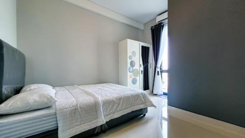 a white bedroom with a bed and a window at Palam Mansion at Apartment One Residence in Batam Center