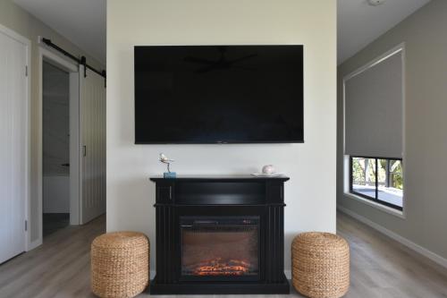 a living room with a fireplace and a flat screen tv at Maleny Hinterland Escape in Witta