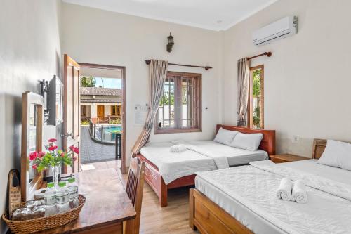 sypialnia z 2 łóżkami i balkonem w obiekcie Nhat Huy Bungalow Phu Quoc w Duong Dong