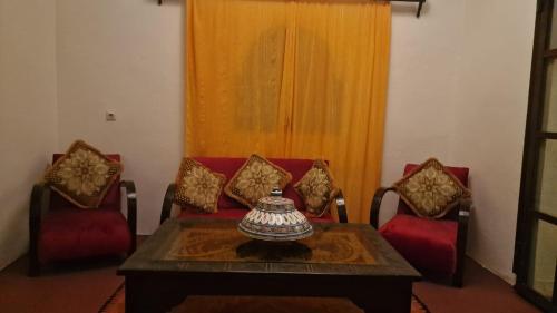 a living room with a table and two chairs at Chez Kossai Atlas Farm in Chtawna