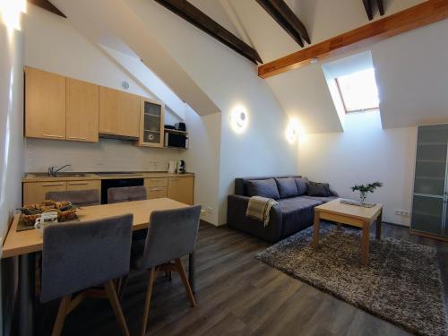 a kitchen and living room with a table and a couch at PUŠIES namai in Nida