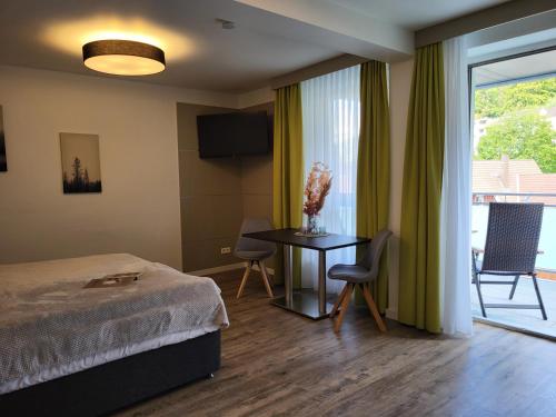 une chambre d'hôtel avec un lit et une table avec des chaises dans l'établissement Gandersheimer Boardinghouse, à Bad Gandersheim