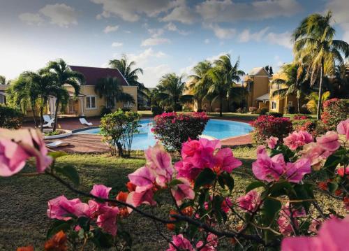 a resort with a swimming pool and pink flowers at Le Rock @ Albion in Albion