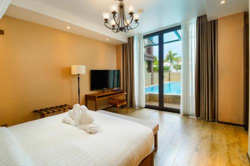 a bedroom with a bed and a tv and a pool at H Resort Bohol - The Coral Cliff by SMS Hospitality in Calape