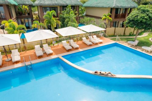 a woman laying in a swimming pool at a hotel at H Resort Bohol - The Coral Cliff by SMS Hospitality in Calape
