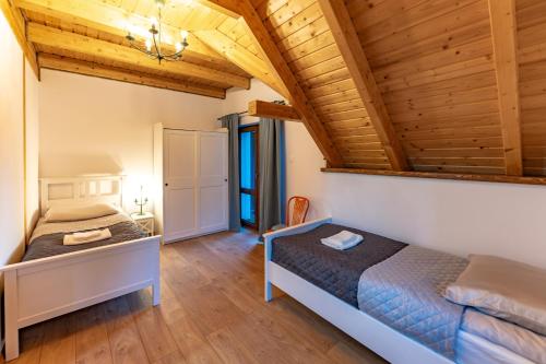 a bedroom with two beds and a wooden ceiling at Apartamenty Przesieka ul. Droga do wodospadu 3 in Przesieka