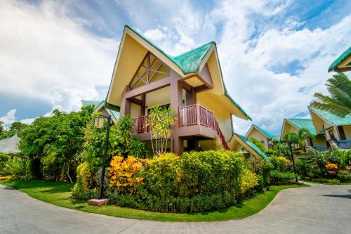 a house with a green roof at H Resort Bohol - The Coral Cliff by SMS Hospitality in Calape