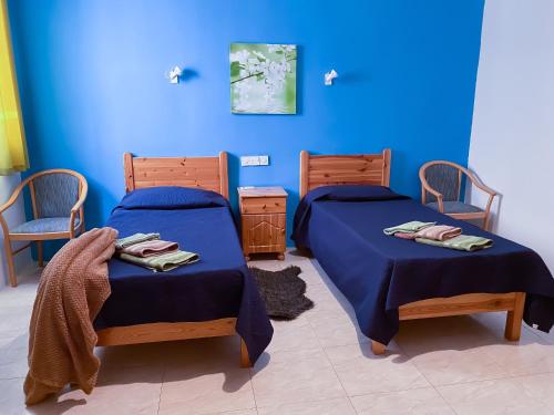 2 camas en una habitación con paredes azules en Gozo Belle Mare Apartments, en Marsalforn