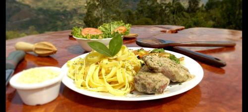 a plate of spaghetti and meatballs on a table at Glamping Cabaña el Porvenir 10601 in Manta