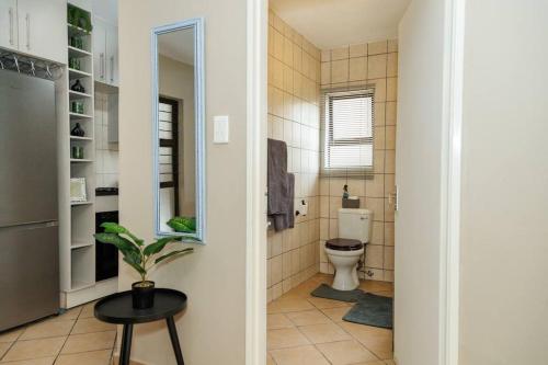 uma casa de banho com WC e um banco preto em Pamuzinda Airbnb at Urban Cove em Nelspruit