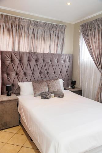 a bedroom with a large bed with a large headboard at Pamuzinda Airbnb at Urban Cove in Nelspruit