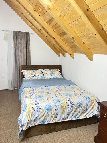ein Schlafzimmer mit einem Bett und einer Holzdecke in der Unterkunft Bajka na dan two bedroom apartment in Bosanska Gradiška