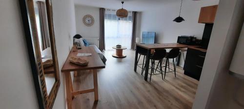 - une cuisine et un salon avec une table et des tabourets dans l'établissement Appartement rénové totalement - Vue sur jardin - 52 m², à Houdemont