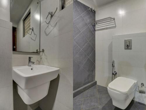 Baño blanco con lavabo y aseo en Rotano Glitz Inn - Glitz Inn Calicut, en Kozhikode