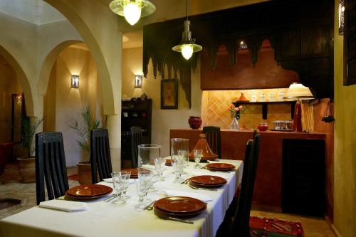 einen Tisch mit Tellern und Gläsern darauf in der Küche in der Unterkunft Villa Allun Essaouira in Essaouira
