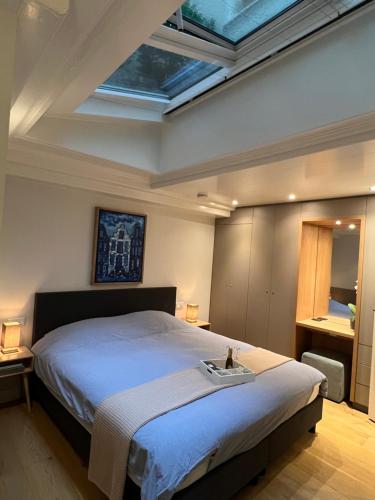 a bedroom with a large bed and a skylight at Singel Residence in Amsterdam