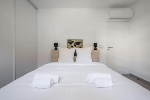 Cama blanca con sábanas y almohadas blancas en Villa Eden - Maison de ville au coeur de Menton, plage à 7 minutes, en Menton