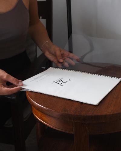 a person is holding a piece of paper on a table at "27" Spathodea- Oasis in the City in Colombo