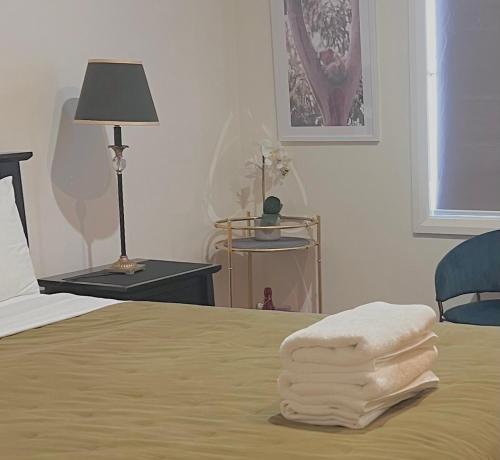 a bedroom with a bed with a stack of towels on it at North Ryde Guesthouse in Sydney