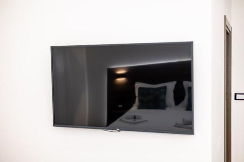 a mirror on a wall with a bed in a room at ForS Konak Apartments in Belgrade