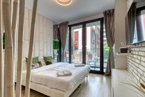 um quarto com uma cama e uma grande janela em Herastrau Luxury Studios em Bucareste