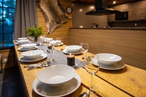 długi stół z białymi talerzami i kieliszkami do wina w obiekcie Tunturipöllö 1 w mieście Ruka