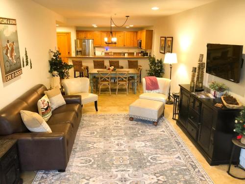 a living room with a couch and a dining room at Bear Creek Lodge 111A by Alpine Lodging Telluride in Telluride