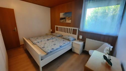 a small bedroom with a bed and a window at Bungalow 39 in Tossens in Butjadingen OT Tossens