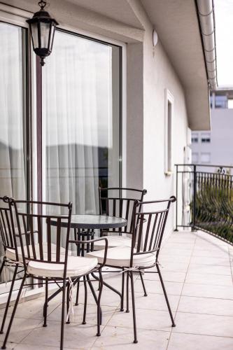 a patio with a table and chairs on a balcony at ForS Konak Apartments in Belgrade