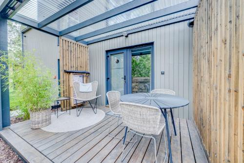 a patio with a table and chairs on a deck at HUS - caloroczne komfortowe szeregi blisko plazy in Pobierowo