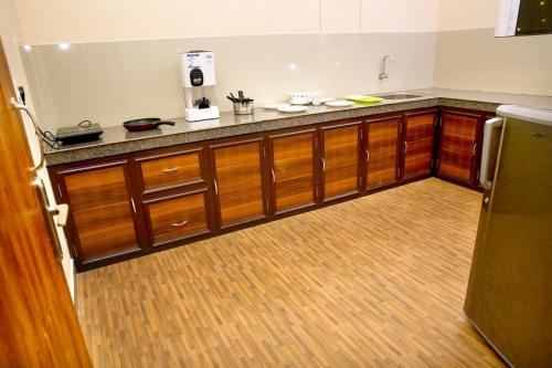 a kitchen with wooden cabinets and a counter top at LOYAL RESIDENCY in Sultan Bathery