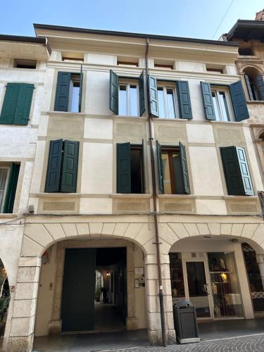 un gran edificio con persianas verdes en Appartamento centro storico Pordenone, en Pordenone