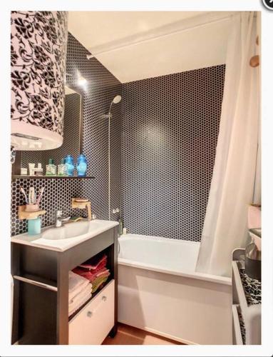 une salle de bain avec un lavabo et une baignoire dans l'établissement Appartement montagnard avec vue sur le Mont-Blanc, à Saint-Gervais-les-Bains