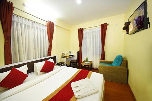 una camera con un grande letto e una TV di Hotel Odyssey Nepal a Kathmandu