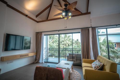 a living room with a ceiling fan and a tv at Tana Mysterious garden in Panglao