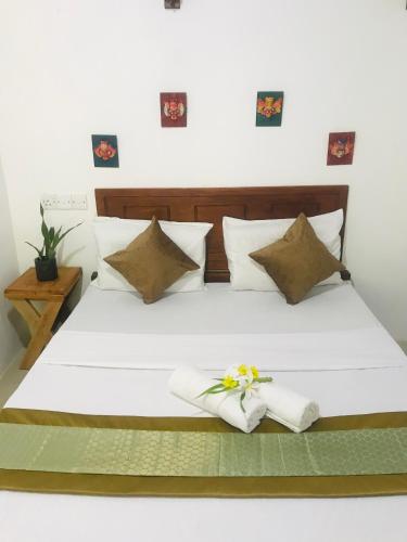 a bedroom with a white bed with a flower on it at The wild culture in Sigiriya