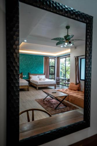 a mirror reflecting a living room with a bed and a couch at Tana Mysterious garden in Panglao