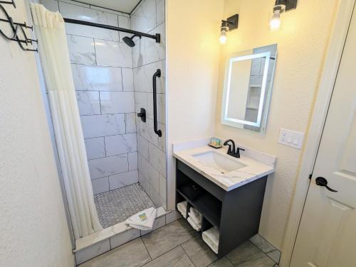 a bathroom with a sink and a shower at Clarion Collection Wilkie's Inn Pacific Grove - Monterey in Pacific Grove