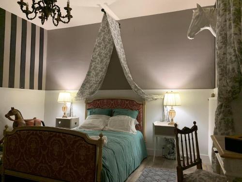 1 dormitorio con 1 cama con cabezal de caballo en la pared en Chambre La Princière, en Lorris