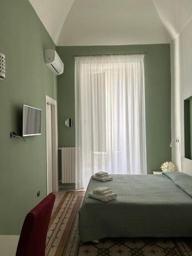 a bedroom with a bed and a large window at La Dimora dell' Architetto in Gravina in Puglia