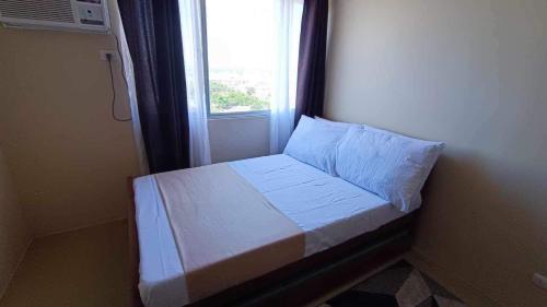 un piccolo letto in una camera con finestra di Nazaire Suite Avida Towers Aspira a Cagayan de Oro