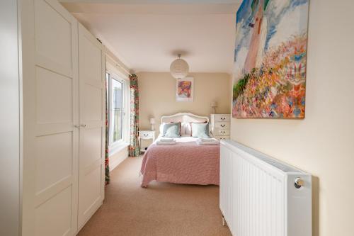 - une chambre avec un lit et une peinture murale dans l'établissement 5 bed Central Cambridge House, à Cambridge