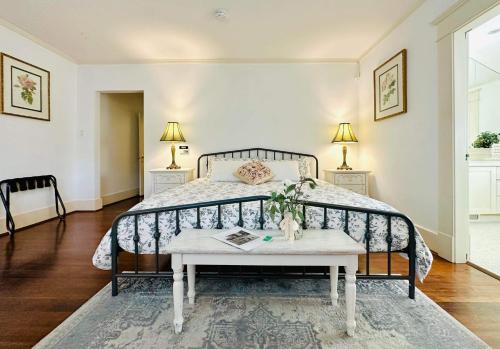 a bedroom with a bed with a table and two lamps at Green Villa in Shaughnessy - Free Parking - Pet-Friendly in Vancouver