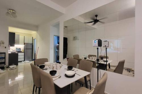 a dining room and kitchen with a white table and chairs at Stay@12 D'Festivo Residence Ipoh Perak in Ipoh