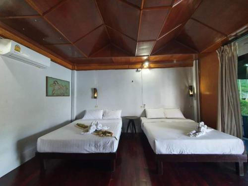 two beds in a room with a ceiling at Family House in Ko Por