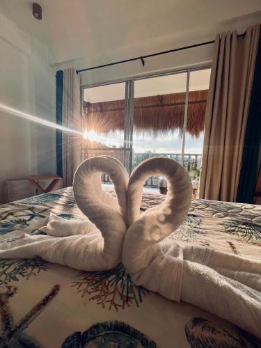 two towel swans are sitting on a bed at La Palapa Inn Port Barton in San Vicente