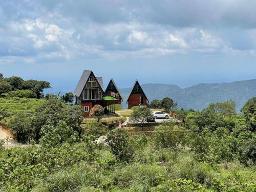 a house on a hill with mountains in the background at EagleRedCasino in Vagamon