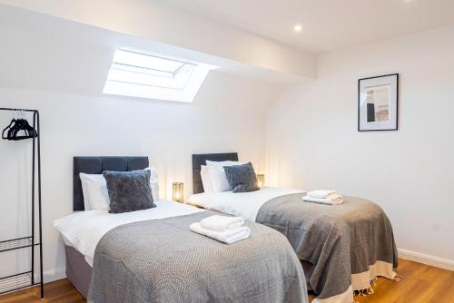two beds in a room with white walls at New Deluxe4beds 2bath Apartment Near Highstreet in Southampton