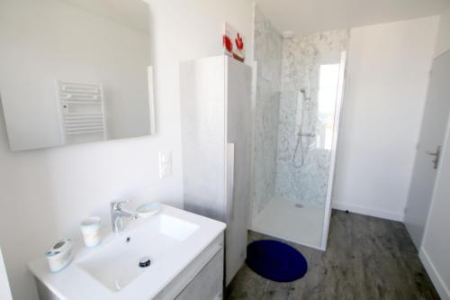 a white bathroom with a sink and a shower at Le gîte de Kelly in Trémont